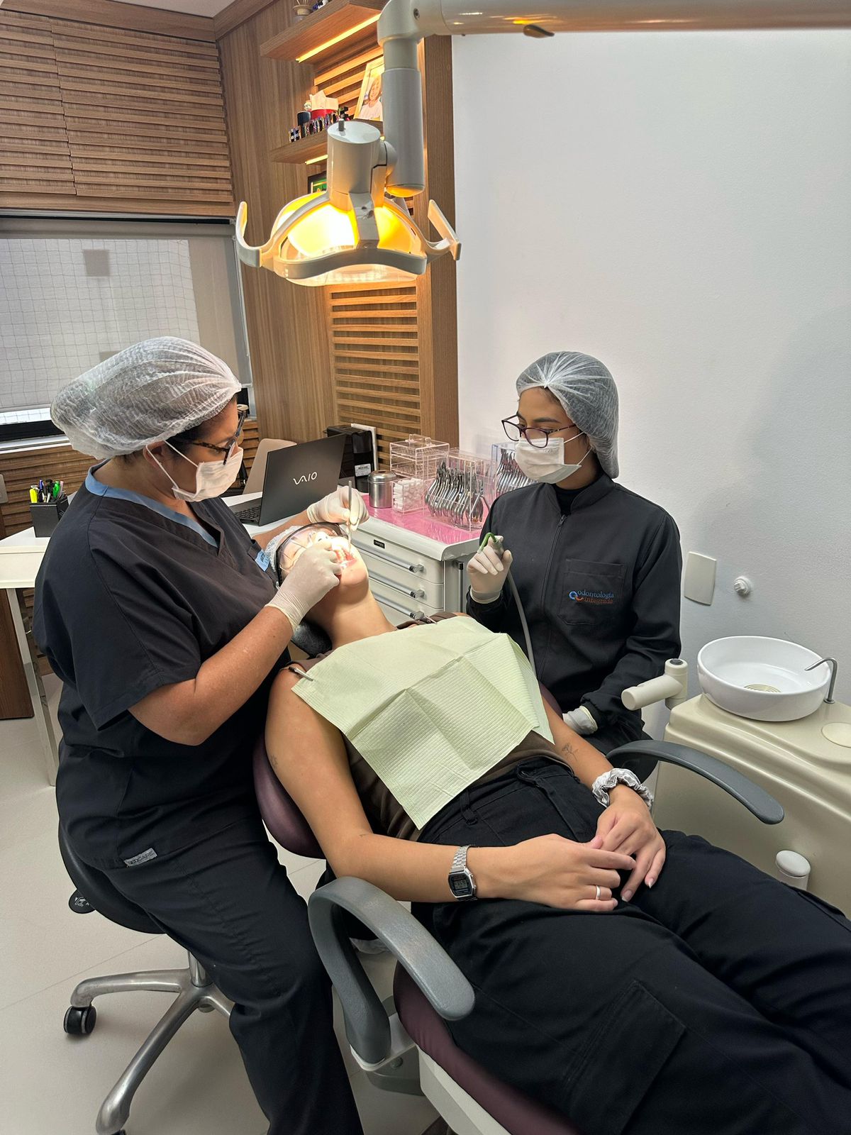 Dr. Ciro e assistente realizando procedimento odontológico com equipamentos modernos